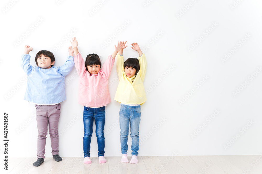 壁に並ぶ3人の幼稚園児 壁に並ぶ3人の幼稚園児