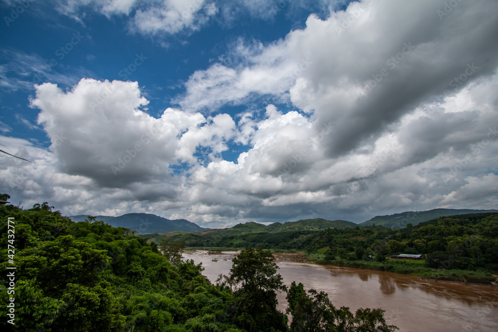 The Mekong River stretches with beautiful sky mountain views.