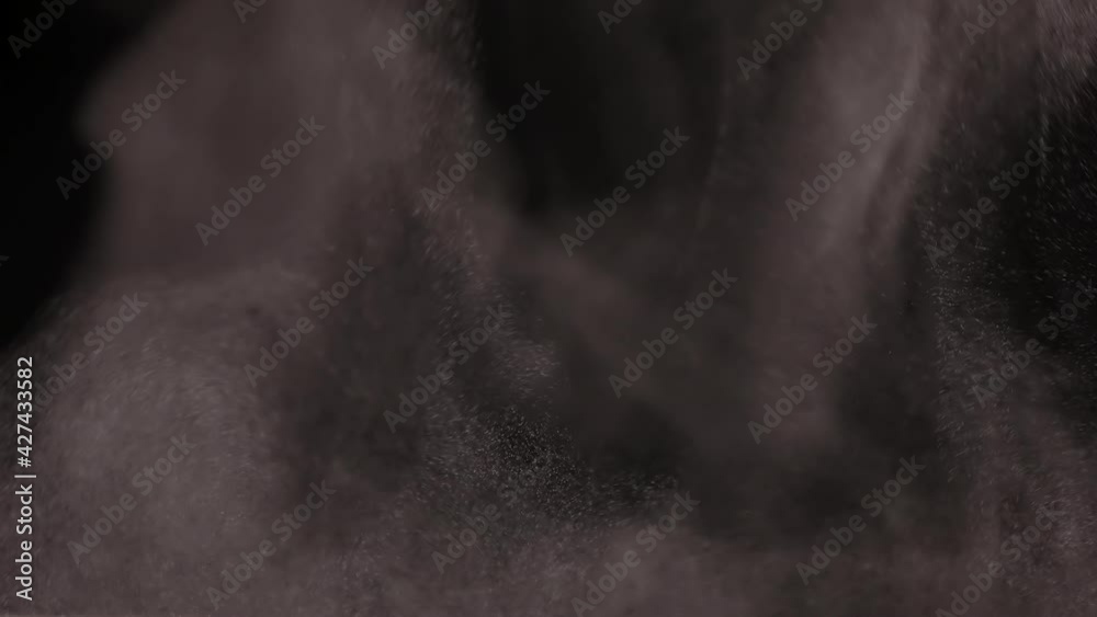 Smoke, steam, fog with dust particles fly against a black background, carried away by the wind in slow motion. Ice cloud of smoke, fiery smoke, rising steam, floating fog. Close up. Smoke, steam, fog with dust particles fly against a black background, carried away by the wind in slow motion. Ice cloud of smoke, fiery smoke, rising steam, floating fog. Close up.