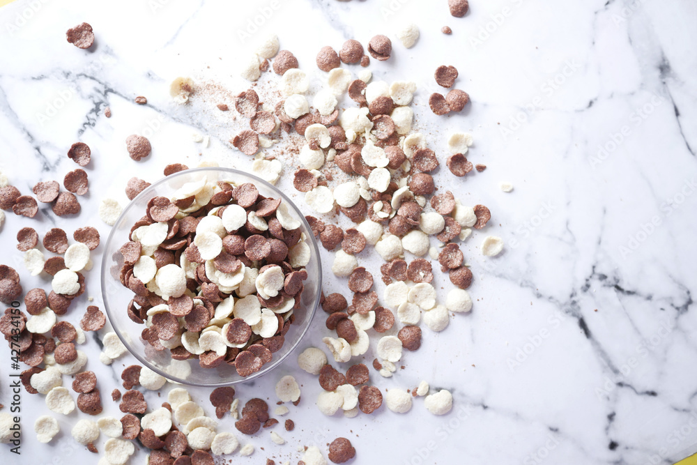 Top view of chocolate corn flakes in a bowl on tiles background Top view of chocolate corn flakes in a bowl on tiles background