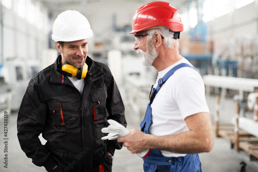 Portrait of workers in factory. Colleagues with helmet working in factory.. Portrait of workers in factory. Colleagues with helmet working in factory..