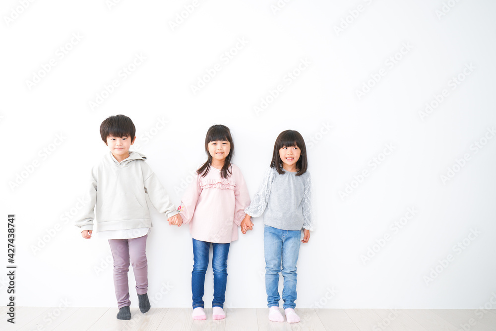 壁に並ぶ3人の子どもたち 壁に並ぶ3人の子どもたち