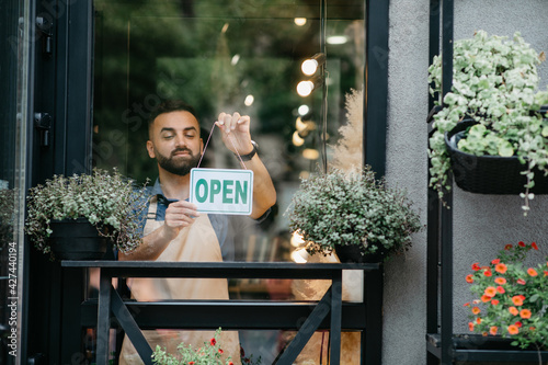 Obraz na plátně Business concept, caucasian man holding open sign indoors in shop