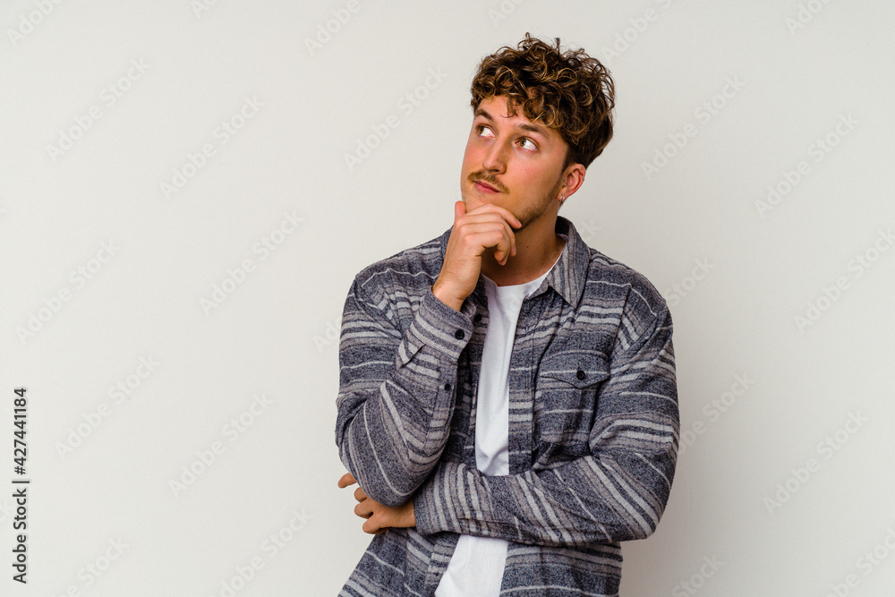 Young caucasian man isolated on white background thinking and looking up, being reflective, contemplating, having a fantasy.