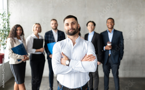 Confident Arabic Businessman Standing In Front Of Employees In Office
