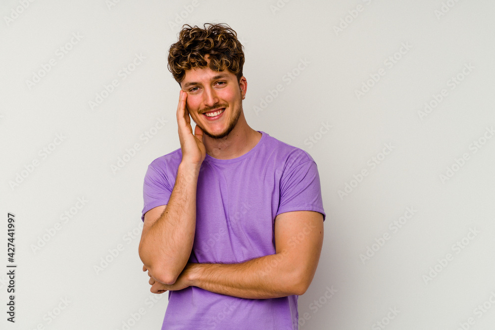 Young caucasian man isolated on white background smiling happy and confident, touching chin with hand. Young caucasian man isolated on white background smiling happy and confident, touching chin with hand.