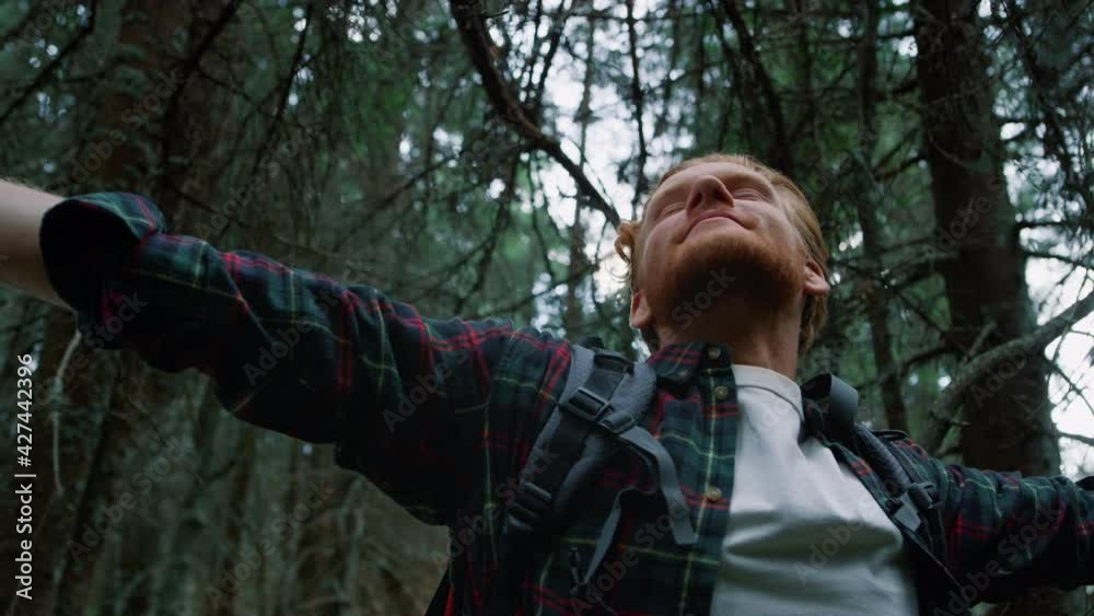 Satisfied guy taking rest during hike in woods. Male tourist enjoying nature Satisfied guy taking rest during hike in woods. Male tourist enjoying nature
