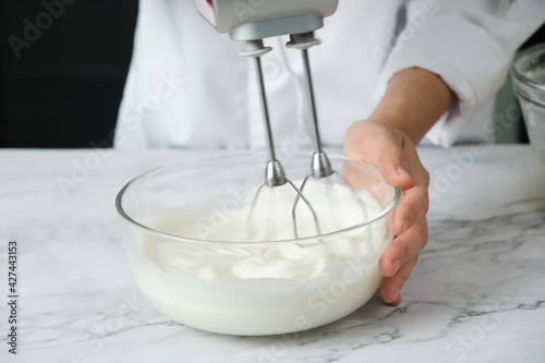 pastry chef preparing mixing meringue for cake and bakery. © Tavan