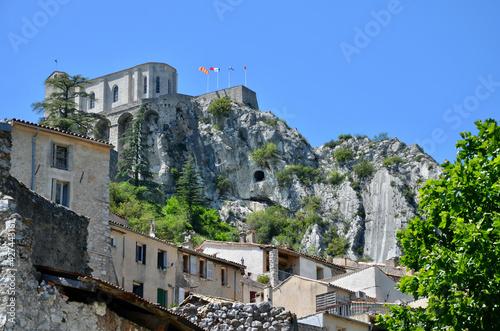 View to the Citadel (fortress) of Sisteron on a rock in Provence-Alpes-Côte d'Azur, old medieval houses below, blue sky background 