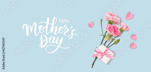 Happy Mothers day. Calligraphic greeting text. Holiday design template with realistic pink carnation flowers, gift box and paper hearts on blue background. Vector stock illustration.