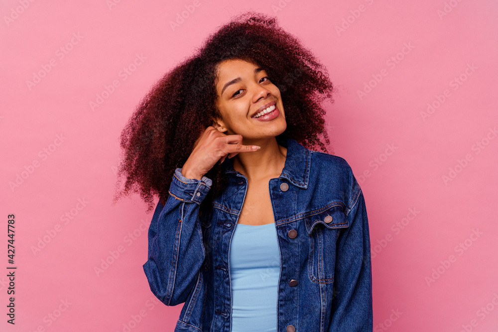 Young african american woman isolated on pink background showing a mobile phone call gesture with fingers. Young african american woman isolated on pink background showing a mobile phone call gesture with fingers.
