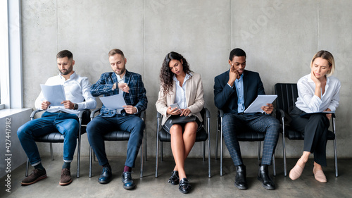 Foto Multiethnic Applicants Waiting For Job Interview Sitting In Row Indoors