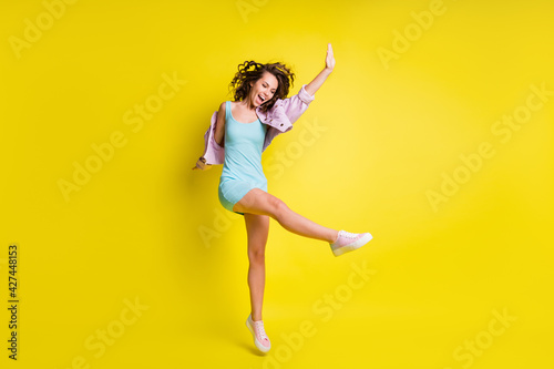 Full size photo of happy excited funky funny girl dancing enjoying weekend free time isolated on yellow color background