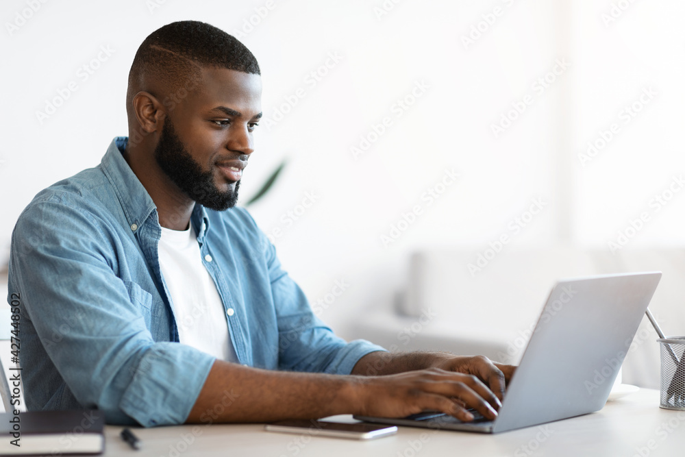 Online Career. Portrait Of Young Black Male Freelancer Typing On Laptop Online Career. Portrait Of Young Black Male Freelancer Typing On Laptop