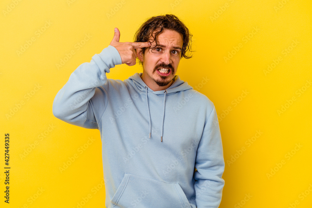 Young caucasian man isolated on yellow background showing a disappointment gesture with forefinger. Young caucasian man isolated on yellow background showing a disappointment gesture with forefinger.