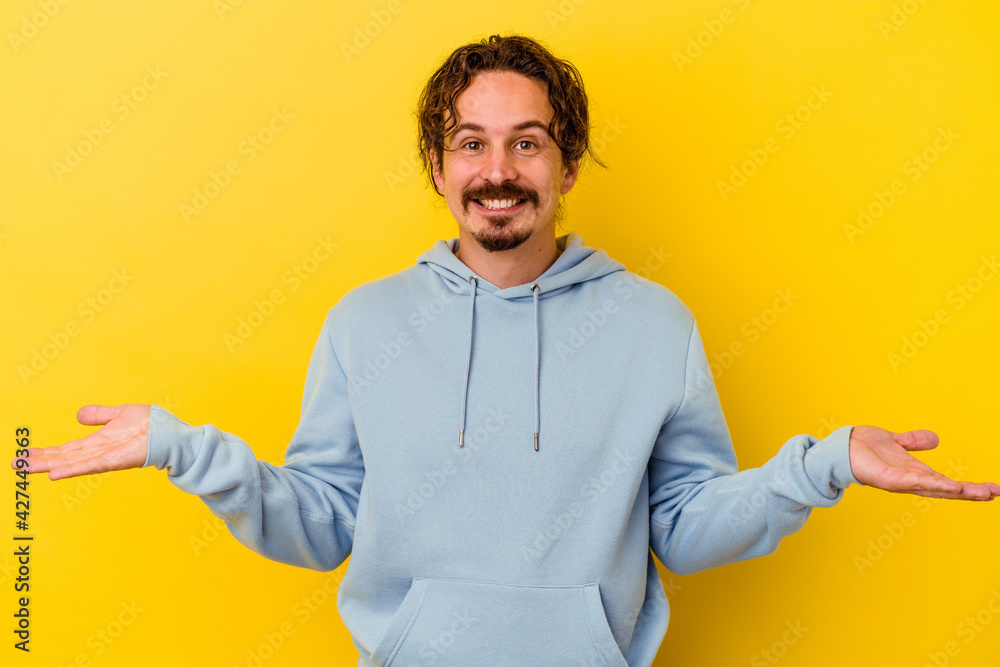 Young caucasian man isolated on yellow background showing a welcome expression. Young caucasian man isolated on yellow background showing a welcome expression.