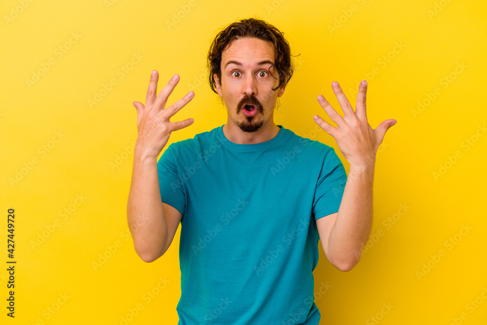 Young caucasian man isolated on yellow background showing number ten with hands. Young caucasian man isolated on yellow background showing number ten with hands.