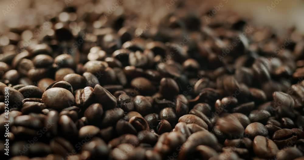 Selected roasted coffee beans fall on a pile. Slow-motion video Selected roasted coffee beans fall on a pile. Slow-motion video