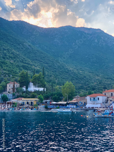 small Greek harbour village at Aegean Sea with large mountains in the background