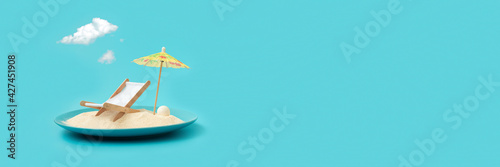 Banner 3:1. Tropical beach concept made of plate with sand, deck chair and sun umbrella. Creative summer vacation concept
