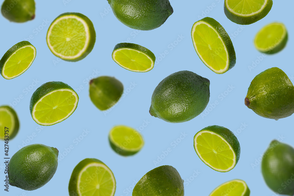 Falling limes isolated on a pastel blue background, Minimal concept