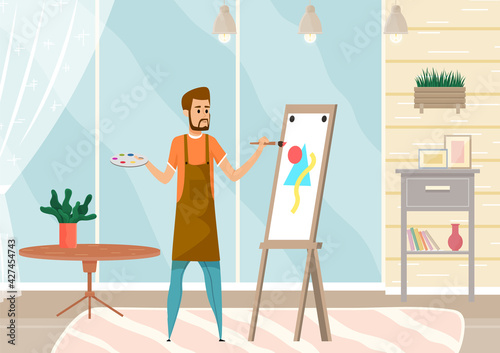 Bearded man drawing picture holding paint brush standing near easel in home interior or art studio