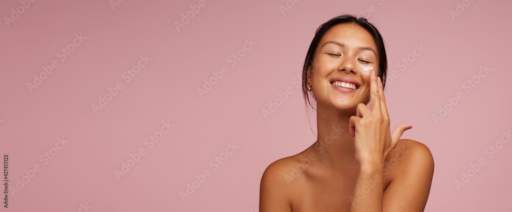 Youthful woman doing her skincare routine - obrazy, fototapety, plakaty 