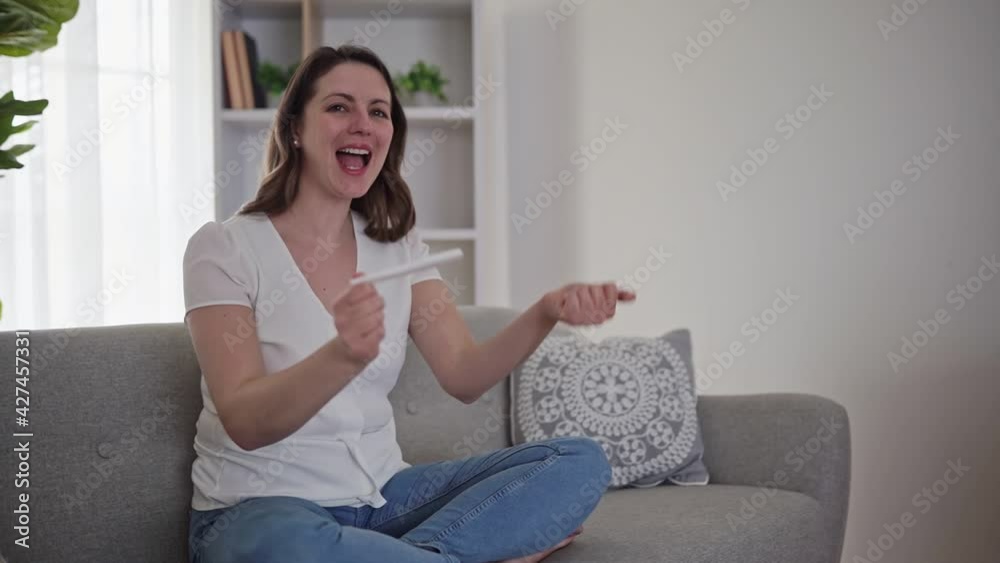 A Smiling and excited girl checking her recent pregnancy test A Smiling and excited girl checking her recent pregnancy test