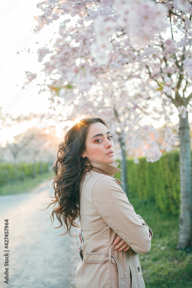 Portrait of a beautiful young woman in blooming sakura at sunset. Spring. Portrait of a beautiful young woman in blooming sakura at sunset. Spring.
