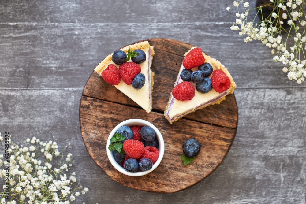 Cheesecake with berries on a grey wooden background. Top view.