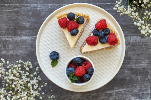 Cheesecake with berries on a grey wooden background. Top view.
