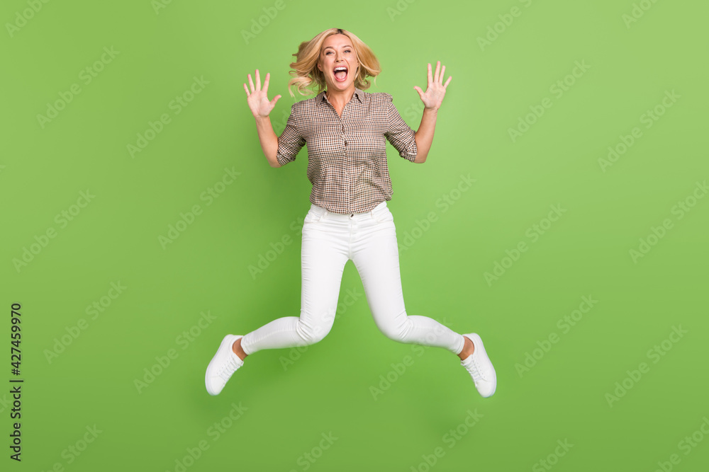 Full length body size photo of jumping woman careless happy isolated on bright green color background