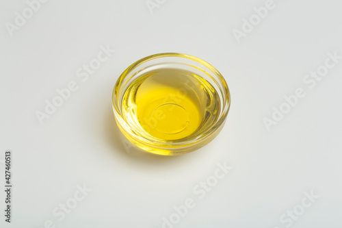 Vegetable oil isolate in a glass bowl. Yellow liquid vegetable oil on white blank background