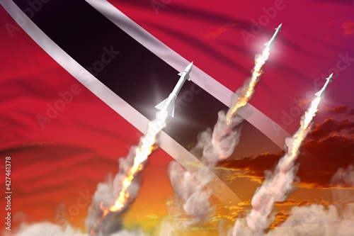 Modern strategic rocket forces concept on sunset background, Trinidad and Tobago supersonic warhead attack - military industrial 3D illustration, nuke with flag photo