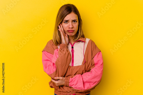 Young caucasian skinny woman isolated on yellow background blows cheeks, has tired expression. Facial expression concept.