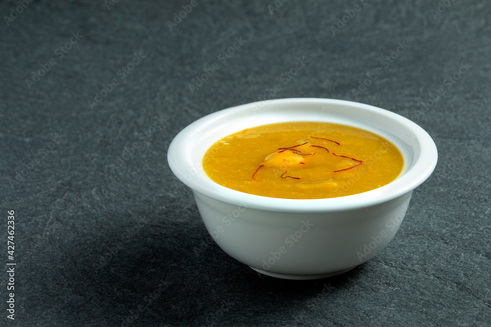 Aamras is plain Haapus or Alphonso Mango Puree/Pulp with kesar/ saffron topping. Aam Ras is a delicious Indian seasonal Dessert recipe. Served in a white bowl on white background Aamras is plain Haapus or Alphonso Mango Puree/Pulp with kesar/ saffron topping. Aam Ras is a delicious Indian seasonal Dessert recipe. Served in a white bowl on white background