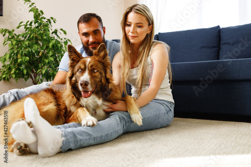 Young loving couple relaxing in living room with their dog pet © fotofabrika