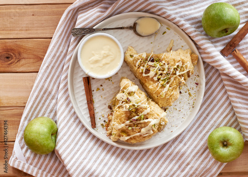 scones with apple, pistachios and white chocolate on a wooden background.