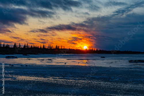 A dramatic orange winter sunset over Hudson Bay, Manitoba, Canada photo