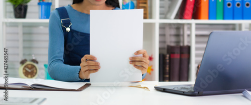 A woman sitting in the office with paper documents.