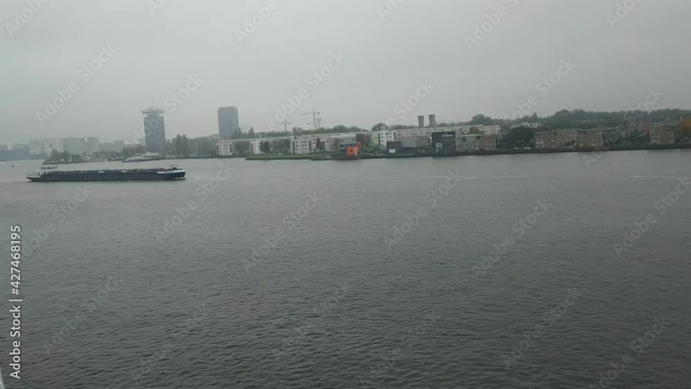 Amsterdam, Netherlands - November 01, 2019: view on the city architecture from channel boat at the autumn weather Amsterdam, Netherlands - November 01, 2019: view on the city architecture from channel boat at the autumn weather