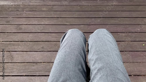 a person who crosses his legs in a wooden chair photo