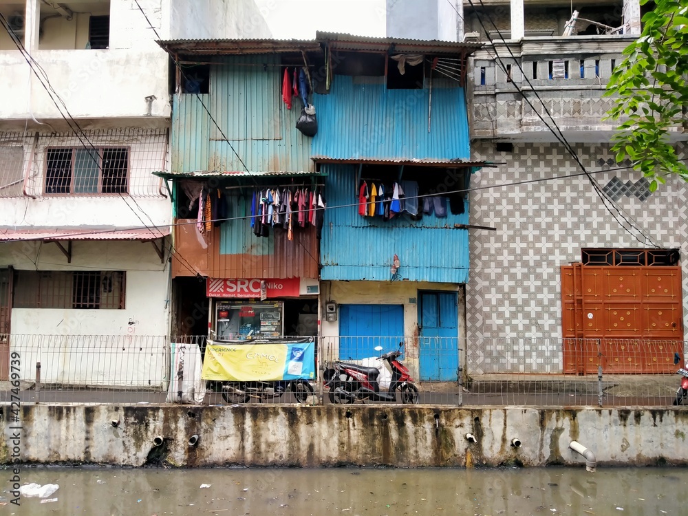 Tambora, jakarta, Indonesia - (04-03-2021) : Slum house in front of a dirty river in a densely populated area Tambora, jakarta, Indonesia - (04-03-2021) : Slum house in front of a dirty river in a densely populated area