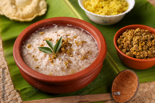 Rice porridge, Kanji, gruel in clay pot palm mat background Kerala South India. congee, rice soup, green gram curry, chammanthi. Ayurveda diet for immunity. porridge Indian Sri lankan veg food. photo