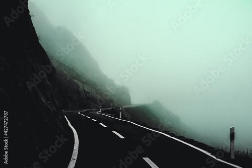 Roadtrip auf Bergstraße bei starkem Nebel in düsterer Stimmung photo