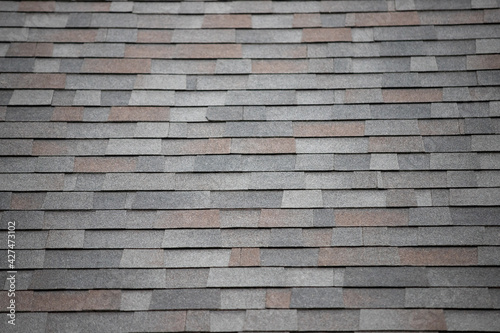 roof shingle background and texture. dark asphalt tiles on the roof © Rattanachat