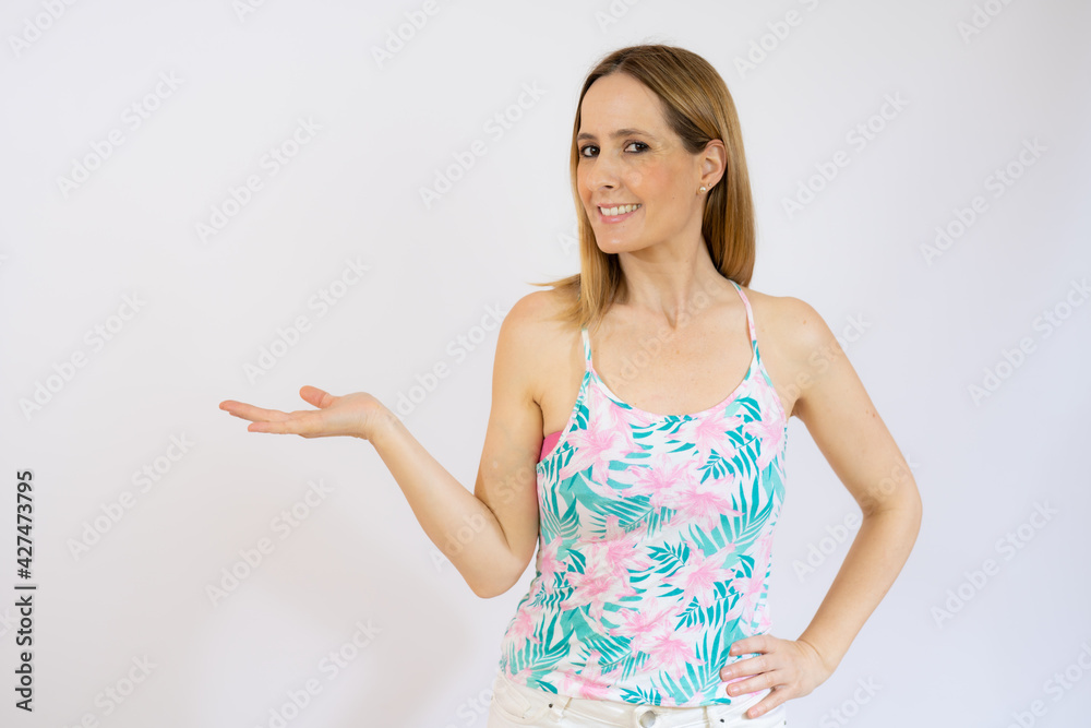 Young smiling woman over isolated background holding something with hand, product presentation. Young smiling woman over isolated background holding something with hand, product presentation.