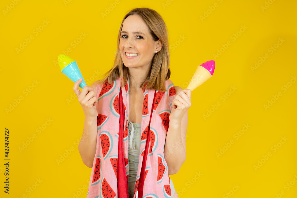 Happy woman wearing swimsuit and beach towel holding two ice creams Happy woman wearing swimsuit and beach towel holding two ice creams