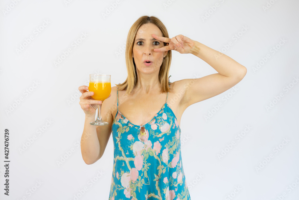 Young smiling woman in casual clothes holding a juice showing victory sign isolated over white background. Young smiling woman in casual clothes holding a juice showing victory sign isolated over white background.