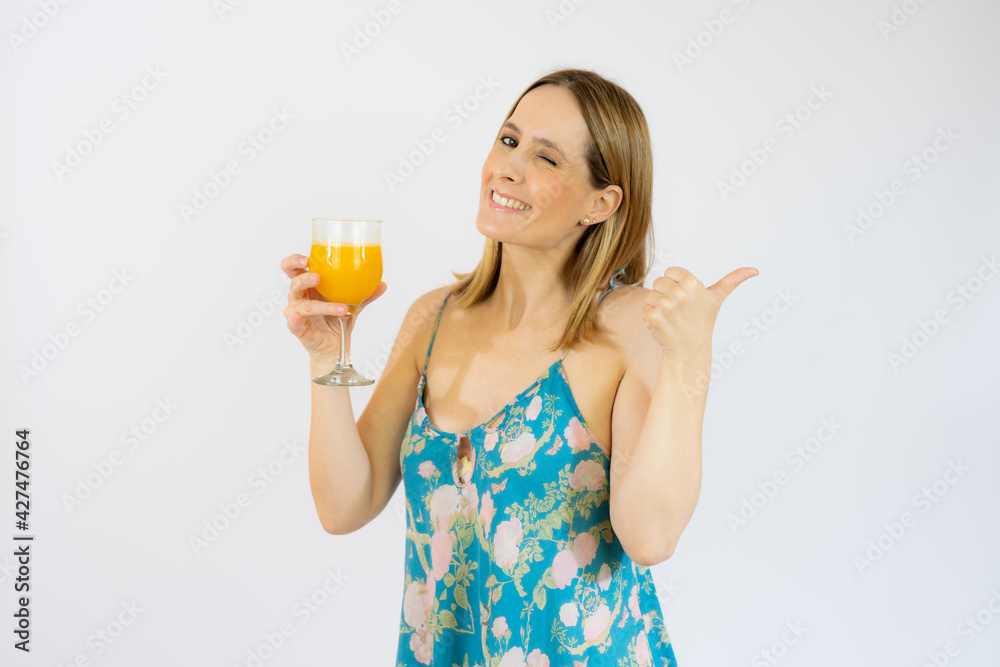 Young smiling woman in casual clothes holding a juice showing thumb up isolated over white background. Young smiling woman in casual clothes holding a juice showing thumb up isolated over white background.